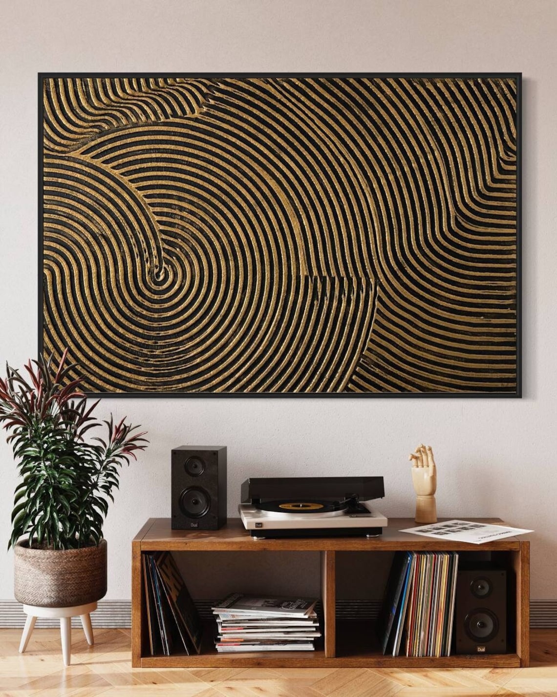 Metallic abstract canvas painting with gold and black concentric circular patterns.