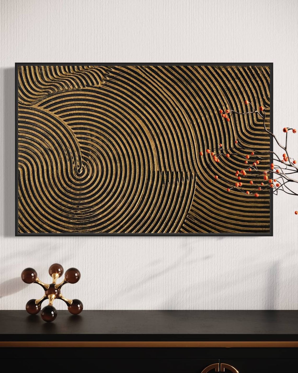 Metallic abstract canvas painting with gold and black concentric circular patterns.