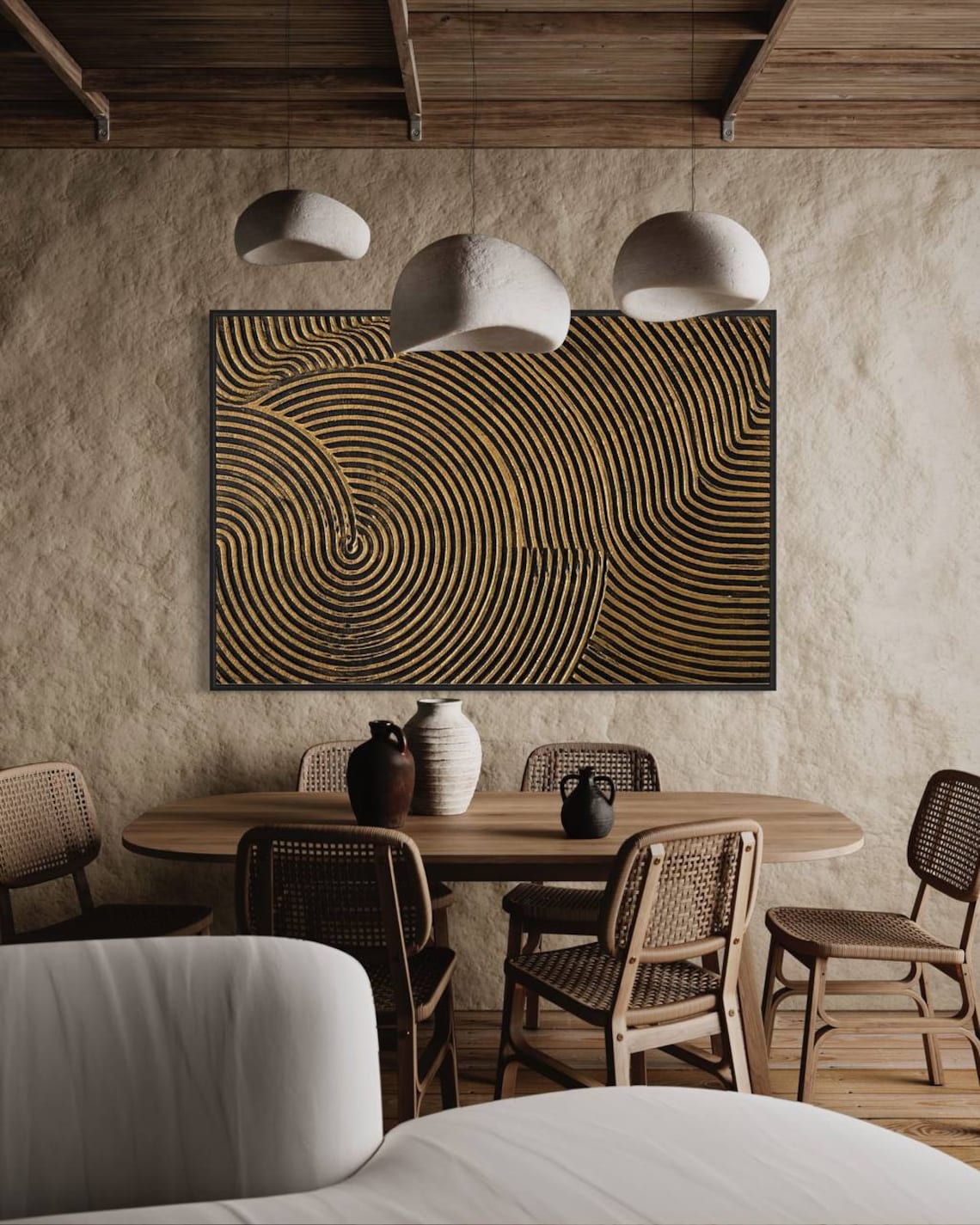 Metallic abstract canvas painting with gold and black concentric circular patterns.